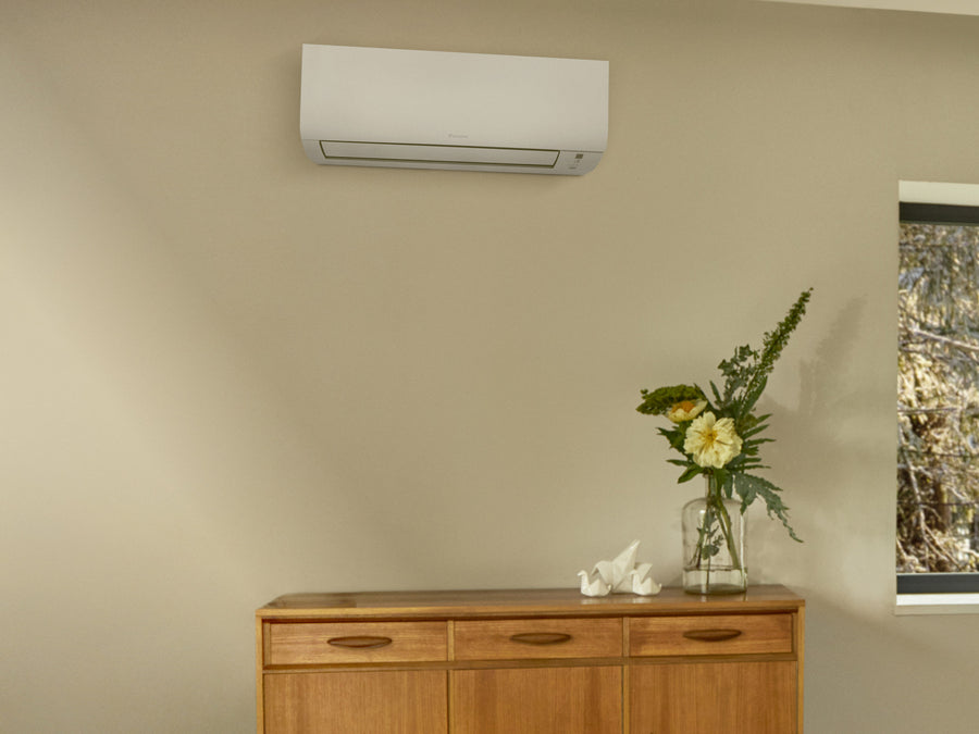 DAIKIN Comfora Nepura FTXTP25A na stene nad drevenou komodou