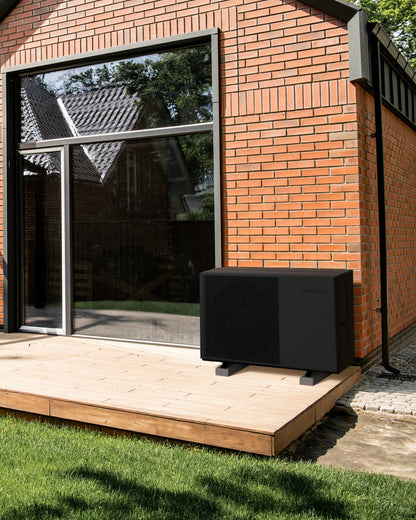 SAMSUNG EHS Quint 16 kW – 200 l · 1 zóna — vonkajšia jednotka Quint pri tehlovom dome s drevenou terasou